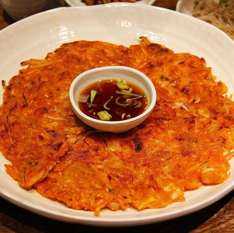 Plate with crispy kimchi pancake and dipping sauce
