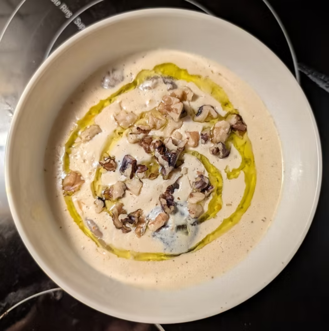 A bowl of creamu mushroom soups with crafty pickles traditional carawaysauerkraut