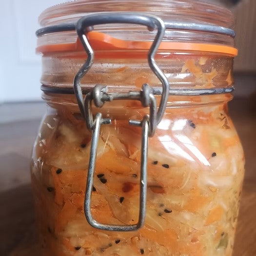 A clip top jar filled with homemade sauerkraut