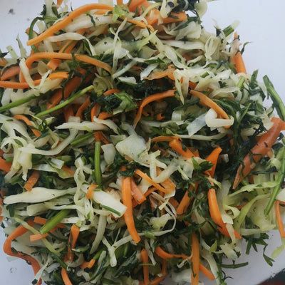 Shredded cabbage, carrot and carrot tops ready to make sauerkraut