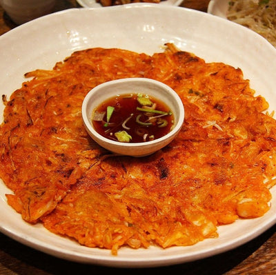 Plate with crispy kimchi pancake and dipping sauce