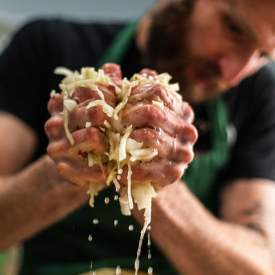 Hands holding shredded cabbage and liquid squeezed out