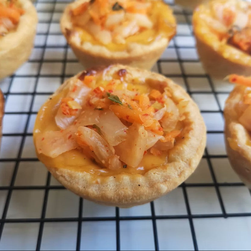 A pastry tartlet filled with cheese and crafty kimchi