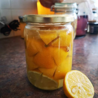 A jar of lemons, with a salt water brine raedy for fermentation