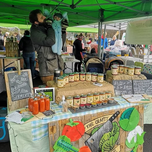 Arthur an dbaby pickle at a market selling fermented foods