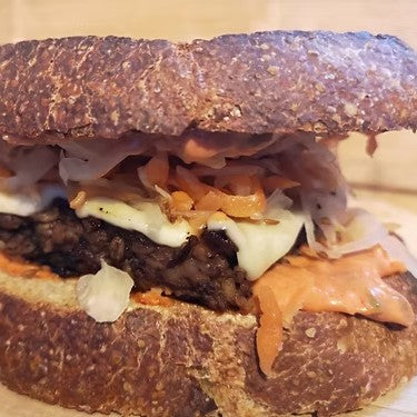 A close up of  tempeh reuben sandwhich with thick crusty bread