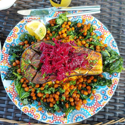 Plate with roasted aubergine chickpeas and kale topped with sauerkraut
