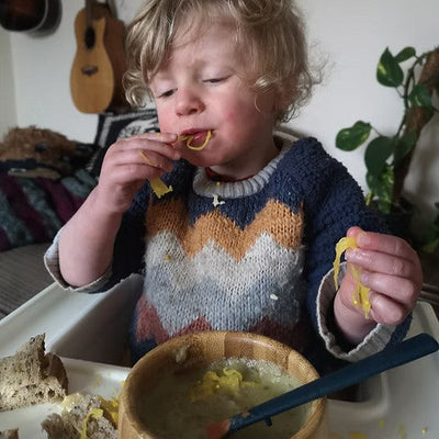 A  toddler eating crafty pickle sauerkraut