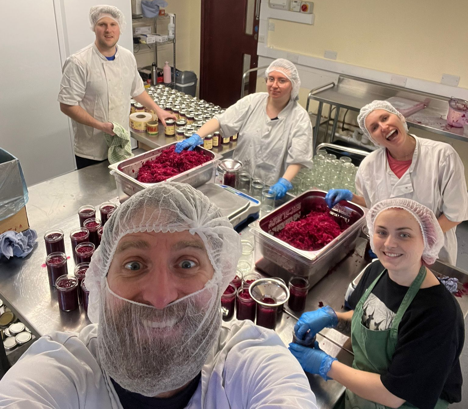 Group of people in a food processing facility taking a selfie.